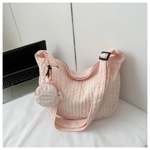 Detailed view of light pink quilted crescent bag with matching round coin purse charm