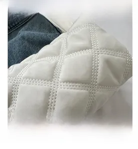 Detail of white quilted rhombic stitching on soft padded nylon shoulder bag