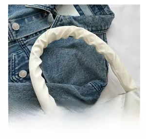 Detail of white quilted handbag featuring a creative ruched cloud-style shoulder strap