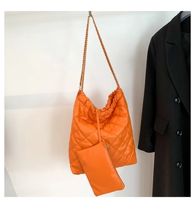 Détail du sac seau matelassé orange avec bandoulière chaîne et pochette assortie
