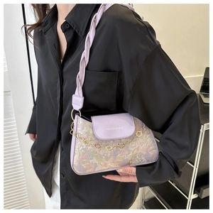 Détail du sac bandoulière en jacquard violet avec motif floral et chaîne dorée prune