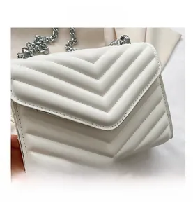 Close-up of white chevron quilted flap bag featuring a chunky silver chain strap
