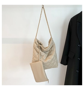Détail du sac fourre-tout matelassé beige avec bandoulière chaîne et petite pochette zippée
