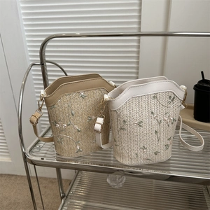 Summer woven straw bucket bag with floral embroidery and adjustable leather strap