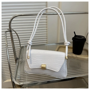 Detail der weißen Unterarmtasche mit Krokodilmuster und eleganter goldener Metallschnalle