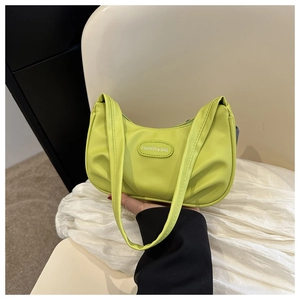 Dettaglio della borsa a tracolla plissettata verde brillante con logo in pelle