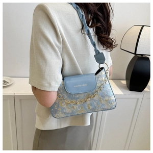 Hellblaue Jacquard-Schultertasche mit geflochtenem Riemen und Ketten-Detail am Model