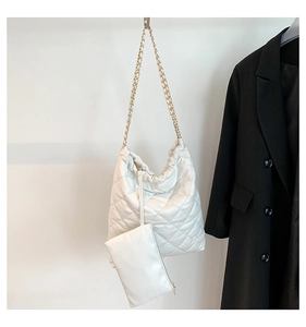Détail du sac seau matelassé blanc avec chaîne dorée et petit sac assorti