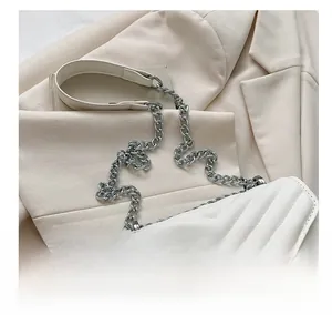 Close-up of white quilted leather bag with silver chain strap and V-shaped stitching