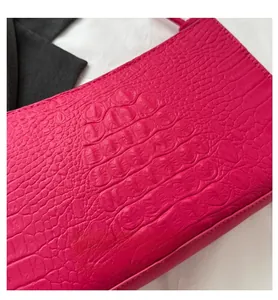 Détail de la texture cuir PU à motif crocodile rose rouge sur le sac à bandoulière