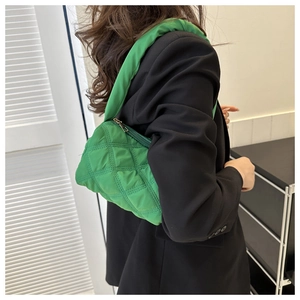 Quilted lime green shoulder bag with padded strap worn over a black blazer jacket