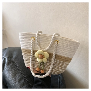 Détail de la texture tissée et de la fleur en peluche sur le sac seau de plage décontracté