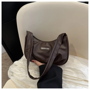 Dettaglio borsa hobo marrone scuro in ecopelle lucida con placca logo ovale di tendenza
