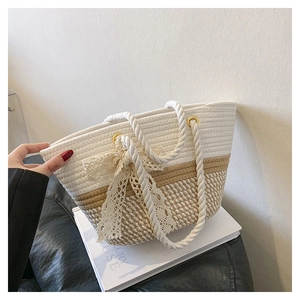 Détail du sac seau tissé avec nœud en dentelle blanche et poignées en corde épaisse