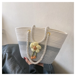 Détail du sac seau tressé avec breloque tournesol et poignée en corde pour plage d'été