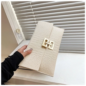 Détail d'un sac à main blanc cassé à motif crocodile avec boucle en métal doré élégante