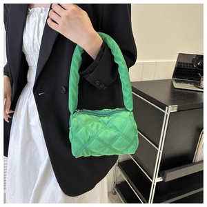 Close-up of bright green quilted nylon handbag with diamond stitching and chunky handle