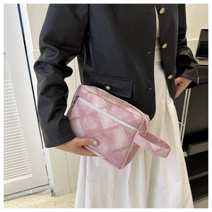 Rosa gesteppte Denim-Kosmetiktasche mit Metall-Reißverschluss und Griff von Model gehalten