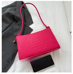 Détail du sac à bandoulière rose fuchsia gaufré crocodile avec poignée nouée