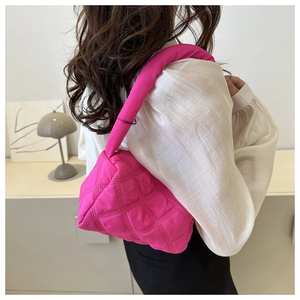 Detailed back view of a fuchsia quilted puffy shoulder bag styled with a white shirt