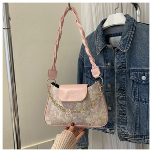 Detailaufnahme der rosa Schultertasche mit Blumenstickerei und goldener Metallkette