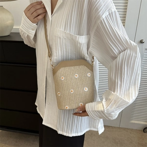 Straw woven crossbody bag with daisy embroidery and adjustable leather strap