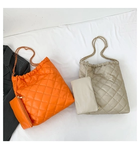 Détail de sac cabas matelassé avec chaîne en métal et pochette zippée assortie incluse
