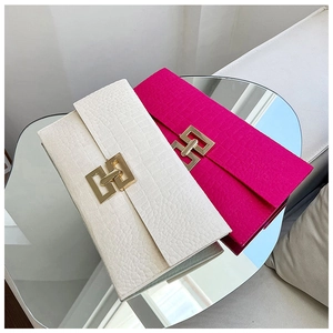 Détail de pochettes rectangulaires élégantes avec texture croco et boucle en métal doré