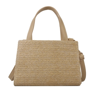 Minimalist beige woven straw tote bag with adjustable leather straps for summer beach vacations