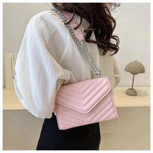 Detail of pink quilted crossbody bag showing V-pattern stitching and silver chain strap