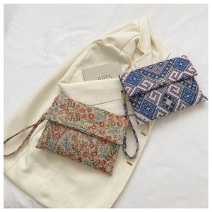 Detail of floral and geometric envelope clutch bags with vintage gold flower clasps