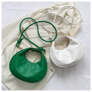 Détails des sacs croissant vert et blanc montrant le cuir mat et les poignées nouées