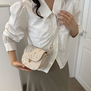 Chic woven crossbody bag with green floral embroidery and golden U-shaped buckle