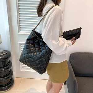 Sac fourre-tout noir matelassé avec bandoulière chaîne et pochette sur mannequin