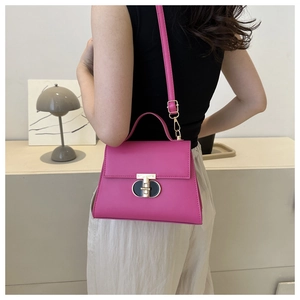 Dettaglio della borsa in pelle fucsia con chiusura girevole bicolore oro e nero