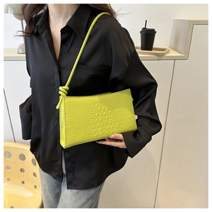 Gros plan du sac porté épaule jaune néon aspect crocodile avec détail de nœud