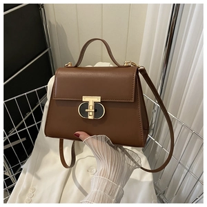Dettaglio della borsa in pelle marrone con elegante chiusura a T in metallo dorato