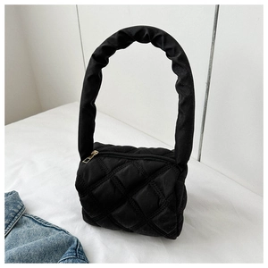 Detail of black quilted nylon bag featuring a puffy rhombus pattern and ruched handle