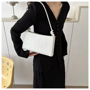 Détail du sac à bandoulière blanc à motif crocodile avec détail de bandoulière nouée