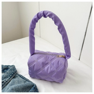 Detail of purple quilted cylindrical handbag featuring soft padded handle and zipper