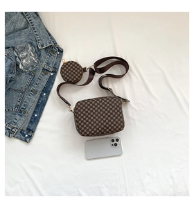 Detail view of printed crossbody bag showing capacity with phone and mini coin purse