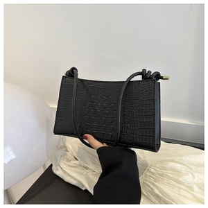 Vue détaillée d'un sac sous le bras noir à motif crocodile avec bandoulière à nœud unique