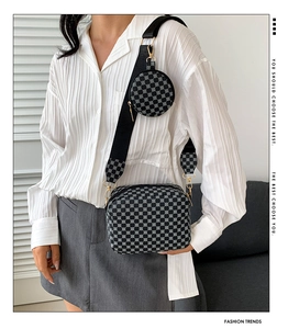 Detail of printed crossbody bag with round pouch and wide shoulder strap on model
