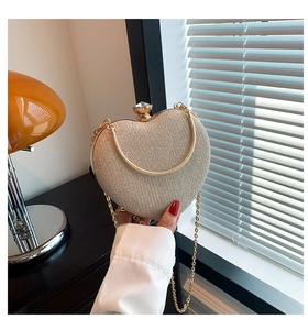 Macro shot of champagne gold heart clutch bag with sparkly sequins and crystal clasp