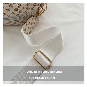 Macro shot of adjustable white nylon strap with gold metal buckle and clover pattern