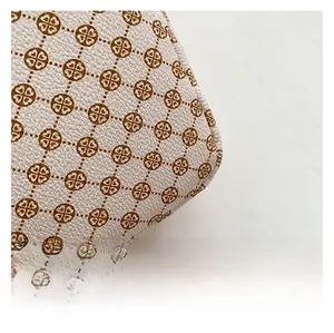Macro shot of grainy faux leather texture with vintage brown clover and heart patterns