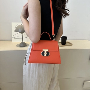 Borsa a tracolla in pelle arancione minimalista con chiusura chic indossata da modella