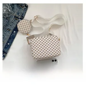 White printed crossbody bag with round coin purse and phone for size reference