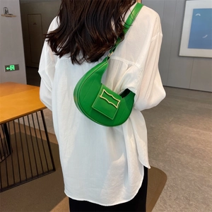 Sac croissant vert citron chic avec boucle dorée porté par un mannequin en intérieur