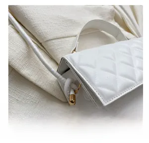 Detail der weißen gesteppten Handtasche mit goldenen Beschlägen und Knotengurt
